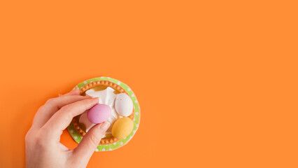 Wall Mural - Sweet tartlets decorated with sweets Easter eggs on an orange bright background, close-up. Copy space. Easter delicious dessert.	