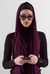 Woman in black stylish fashionable clothes Muslim headscarf. Lady using smart phone, close up portrait of smiling middle eastern girl.