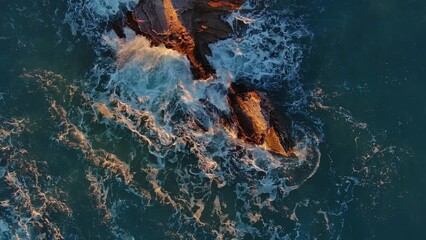 Wall Mural - Aerial top view of waves and rocks in the sea, slow motion, 4k