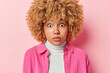 © wayhome.studio - Omg concept. Impressed woman with blonde curly hair stres with amazement emotionally reacts to news has bugged eyes wears white turtleneck and shirt poses against pink background gets shocking offer