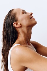 A woman with long, wet hair sits with her head tilted back after washing. Taking care of your hair and scalp