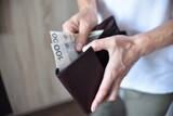 Fototapeta  - Mężczyzna trzymający portfel z gotówką.