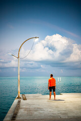 Wall Mural - man looking at  sunset cloud over tropical sea freedom