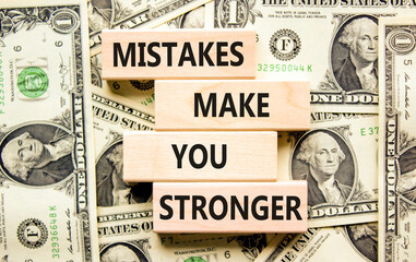 Wall Mural - Mistake make stronger symbol. Concept words Mistakes make you stronger on wooden blocks. Dollar bills. Beautiful background from dollar bills. Business mistake make stronger concept. Copy space.