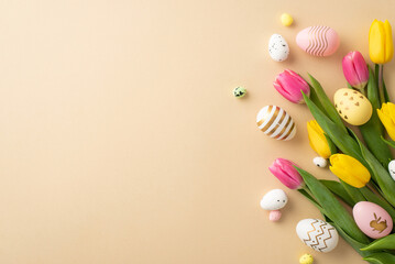 Wall Mural - Easter celebration concept. Top view photo of colorful easter eggs yellow and pink tulips on isolated pastel beige background with copyspace