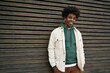 © insta_photos - Young happy African American hipster teen guy standing at wooden wall background. Smiling cool stylish trendy gen z teenage student model looking at camera posing for authentic portrait outdoors.
