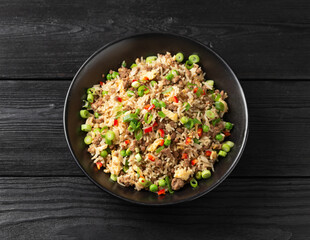 Wall Mural - Asian Beef Fried Rice with eggs and vegetables in black bowl