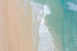 Aerial view of a beach with idyllic tropical blue water and gentle waves 