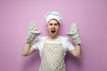 shocked baker in uniform with gloves raises his hands up and shouts, chef in apron in stress