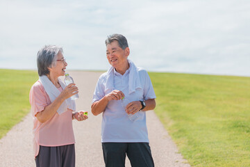 Poster - 公園でウォーキング・有酸素運動する高齢者夫婦（シニア・男女）（水を飲む）
