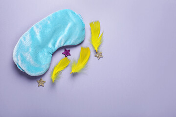 Poster - Soft sleep mask, confetti in shape of stars and feathers on purple background, flat lay. Space for text