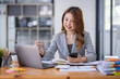 © David - Smiling young Asian business woman executive looking at smartphone using cellphone mobile cell tech, happy ethnic professional female worker working in office typing on cellphone sitting at desk.