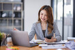 © David - Smiling young Asian business woman executive looking at smartphone using cellphone mobile cell tech, happy ethnic professional female worker working in office typing on cellphone sitting at desk.
