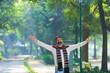 © PRASANNAPIX - Indian man spreading hand and giving expression at park.