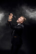 © zamuruev - Portrait of emotive man in suite singing in microphone on black background, singer, actor, leading