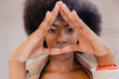 © Westend61 - Young woman making triangle gesture with hands