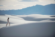 Woman Walking In Desert, White Sands National Monument, New Mexico, USA