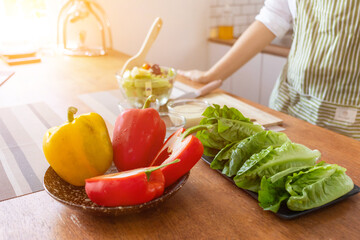 young woman preparing bell Pepper as a breakfast ingredient and ready for healthy cooking and on the table there are vegetables that are healthy organic ingredients. healthy food preparation ideas