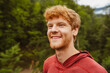 © Drobot Dean - Cheerful redhead man smiling while standing outdoors