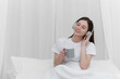 © itchaznong - Portrait of Good Healthy woman drinking tea and resting in bed at bedroom. Lifestyle at home concept