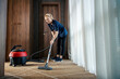 © Dusan Petkovic - A chamber maid is using vacuum cleaner to cleanup hotel room.