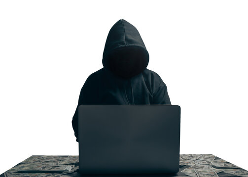 anonymous young man hacker sitting playing laptop with lots of money lying around.concept massive fi