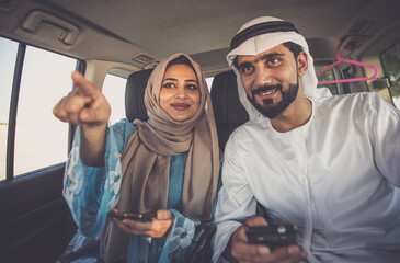 Happy couple driving the car in Dubai. Man and woman going out for shopping. Concept about relationship in the uae