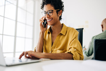 Wall Mural - Female accountant talking on a phone call in an accounting firm