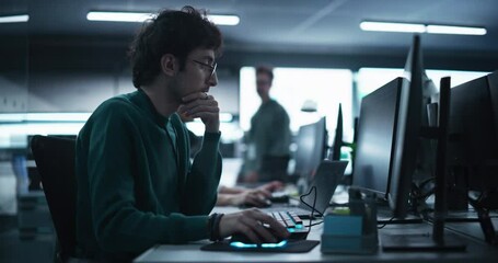 Fototapete - Portrait of a Thoughtful Engineer Working on Desktop Computer in a Technological Office Environment. Research and Development Department Writing Software Code for an Innovative Internet Project
