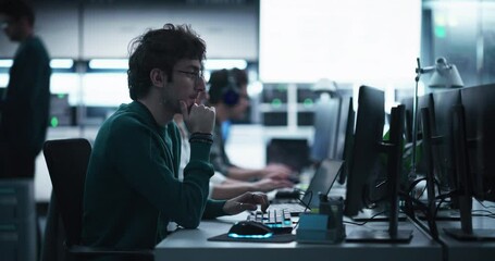 Fototapete - Handsome Software Developer Working on Computer in a Technological Laboratory Environment. Young Man is Thoughtful at His Workplace, Drafting Research Ideas for an AI Development Blockchain