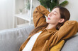 © Pormezz - Young woman enjoying mind free moment relax and calm on the sofa at home.