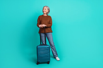 Sticker - Full length portrait of positive cheerful lady suitcase look empty space ad isolated on turquoise color background