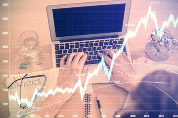 Poster - Double exposure of man's hands typing over laptop keyboard and forex chart hologram drawing. Top view. Financial markets concept.