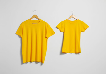 Sticker - Hangers with different t-shirts on light wall. Mockup for design