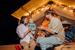© bondvit - Happy family with lovely baby relaxing and spend time together in glamping on summer evening near cozy bonfire. Luxury camping tent for outdoor recreation and recreation. Lifestyle concept