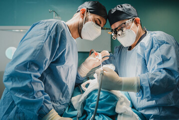 Wall Mural - Medical doctors team operating patient in surgical room at hospital - Focus on surgeons faces