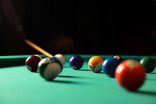 Many Colorful Billiard Balls And Cue On Green Table Indoors