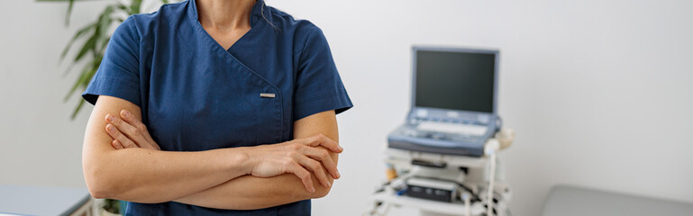 Wall Mural - Smiling doctor, ultrasound specialist looking at camera on her workplace in clinic