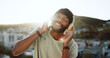 © Siphosethu F/peopleimages.com - Man, music and dancing on rooftop with headphones in sunshine, city and summer with smile. Happy, black man and streaming to listen on internet, web or app to relax, dance and radio in Cape Town