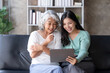 © amnaj - Happy Asian mother and daughter using tablet for video call at home on vacation.