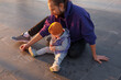 Dad and child draw with chalk on the pavement.