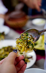 Close up bite of Vietnamese vermicelli with clams mixed on rice cracker, hen xuc banh da.