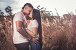 © DouglasCala - Pareja en un campo de espigas y trigo besándose en un atardecer