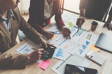 Wall Mural - A group of Asian businessmen are meeting, planning and discussing data analysis, growth charts, graphs, financial calculations, marketing, revenue management. Various taxes within the joint office.