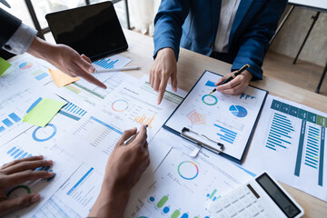 Wall Mural - Asian business people brainstorming in a graph analytical computing plan meeting. data chart Marketing growth. Finance. The concept of business success statistics.