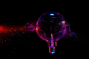 Fototapete - large filament bulb breaks and creates fragments.