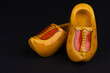 Yellow colored and painted characteristic Dutch wooden shoes.