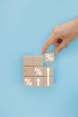 Interest rate and dividend concept, wooden block with percentage symbol and up arrow, return on stocks and mutual funds, long term investment for retirement