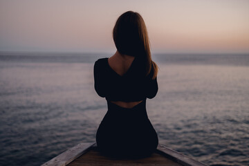 lonely girl sitting on the pier