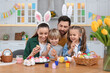 © New Africa - Happy family painting Easter eggs at table in kitchen
